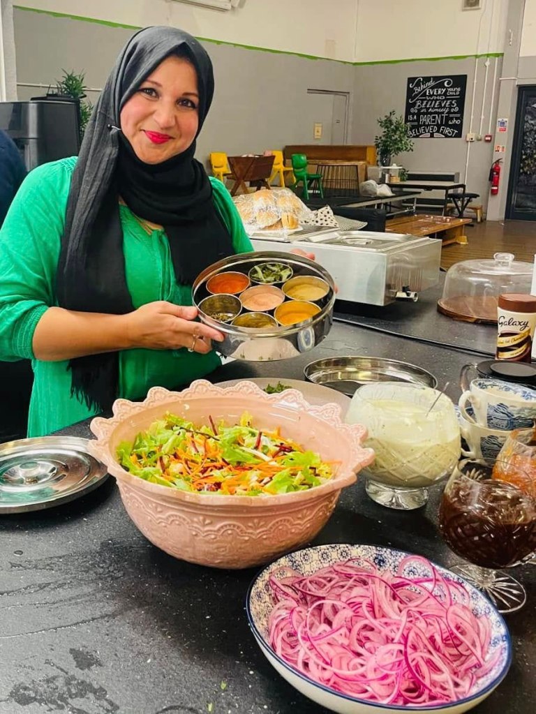 a smiling woman holds up some lovely bowls of food