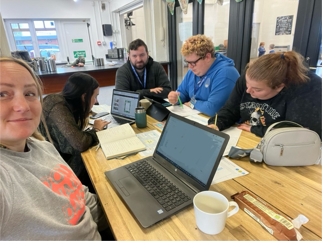 a table of volunteers have a meeting with laptops on the table